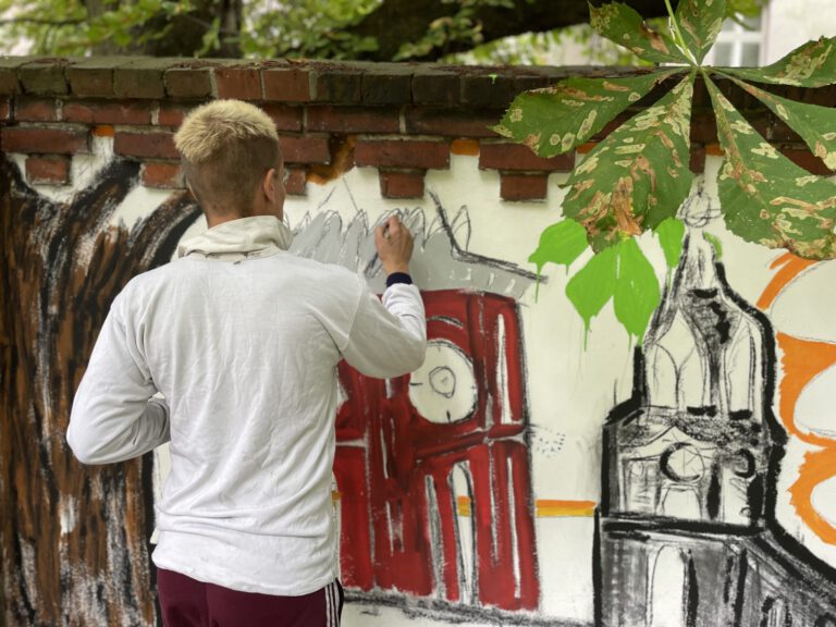 Klient*innen verschönern die Mauern im Garten der Lückstraße